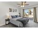 Cozy main bedroom with a ceiling fan, neutral paint, and sliding glass doors to the patio at 718 W Vine Ave, Mesa, AZ 85210