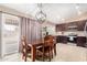 Charming dining area and kitchen featuring dark cabinetry, modern light fixture and patio access at 7214 W Crest Ln, Glendale, AZ 85310