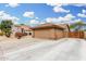 A two car garage with desert landscaping and a side gate at 7214 W Crest Ln, Glendale, AZ 85310