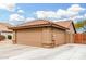 A two car garage with desert landscaping and a side gate at 7214 W Crest Ln, Glendale, AZ 85310