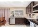 Well-equipped kitchen with stainless steel appliances, granite countertops, and dark wood cabinetry at 7214 W Crest Ln, Glendale, AZ 85310