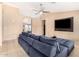 Inviting living room with neutral walls, tile floors, a ceiling fan, and a comfy blue sofa at 7214 W Crest Ln, Glendale, AZ 85310