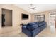 Open living room featuring a ceiling fan, large windows, tile flooring, and a comfy blue sofa at 7214 W Crest Ln, Glendale, AZ 85310