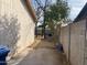 An exterior side yard is shown with a concrete path, block wall, and wood-sided building at 723 E Garnet Ave, Mesa, AZ 85204