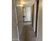 Hallway view featuring updated flooring and multiple doors leading to various rooms at 723 E Garnet Ave, Mesa, AZ 85204