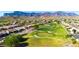 Aerial view of a community featuring a lush green golf course surrounded by houses and mountain views at 8199 E Sweet Acacia Dr, Gold Canyon, AZ 85118