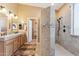 Well-lit primary bathroom with a walk-in shower, double sink vanity with under cabinet storage, and neutral tile flooring at 8212 E Masters Rd, Gold Canyon, AZ 85118