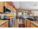 Well-appointed kitchen featuring modern appliances, wooden cabinets, and a seamless flow into the dining area at 8212 E Masters Rd, Gold Canyon, AZ 85118