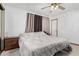 This bedroom features a ceiling fan, neutral walls, and a large bed with a patterned comforter at 917 N Nina Dr, Mesa, AZ 85201