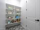 Neat pantry with ample shelving and storage for household items and supplies, on top of stylish tile flooring at 9398 E Cloudview Ave, Gold Canyon, AZ 85118