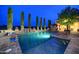 Backyard pool and spa illuminated, with an outdoor dining area, lounge chairs and manicured landscaping at 9547 N 55Th St, Paradise Valley, AZ 85253