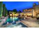 A backyard pool and spa are illuminated at night, with an outdoor dining area and manicured landscaping at 9547 N 55Th St, Paradise Valley, AZ 85253