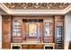 Stylish bar features custom wood cabinets, a wine refrigerator, and decorative ceiling at 9547 N 55Th St, Paradise Valley, AZ 85253