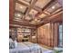 Luxurious bedroom featuring rich wood paneling, coffered ceilings, and built-in bookshelves at 9547 N 55Th St, Paradise Valley, AZ 85253