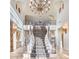 Elegant foyer with a grand staircase, high ceilings, arched windows, ornate chandelier and travertine floors at 9547 N 55Th St, Paradise Valley, AZ 85253