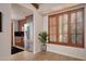 Partial view of a modern kitchen with wood floors, stainless refrigerator and a shuttered window at 9547 N 55Th St, Paradise Valley, AZ 85253