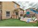 A landscaped backyard has an outdoor bar area, putting green, sun loungers, and a charming pool at 9621 N 82Nd Ln, Peoria, AZ 85345