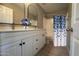 A well-lit bathroom has a double sink vanity, modern fixtures, and a shower with a new shower curtain at 9621 N 82Nd Ln, Peoria, AZ 85345