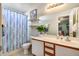 Bathroom with a striped curtain, white vanity, and ample counter space at 12766 W Dreyfus Dr, El Mirage, AZ 85335