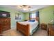 Comfortable bedroom with ceiling fan, green painted walls, and tile flooring at 12766 W Dreyfus Dr, El Mirage, AZ 85335