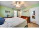 Bright bedroom with ceiling fan, tile flooring, and a view into the en-suite bathroom at 12766 W Dreyfus Dr, El Mirage, AZ 85335