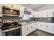 Modern kitchen featuring stainless steel appliances, custom cabinets, and stylish backsplash at 12766 W Dreyfus Dr, El Mirage, AZ 85335