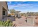 An outdoor patio area with BBQ, dining set, desert plants, and flagstone leading into the house at 13121 S 178Th Ave, Goodyear, AZ 85338