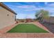 Landscaped backyard featuring a grass area, patio swing, desert plants, and privacy fence at 13121 S 178Th Ave, Goodyear, AZ 85338