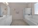 Bright bathroom featuring double sinks, a glass shower, and a soaking tub beneath a glass block window at 13121 S 178Th Ave, Goodyear, AZ 85338