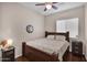 Cozy bedroom with dark wood furniture, ceiling fan and window at 13121 S 178Th Ave, Goodyear, AZ 85338