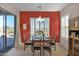 Dining area featuring an accent wall, shuttered windows, and access to backyard at 13121 S 178Th Ave, Goodyear, AZ 85338