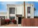 Exterior view of charming townhome with red flowers, black door, and white brick at 13204 N 3Rd Way, Phoenix, AZ 85022