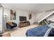 Comfortable living room features neutral tile, cozy chair, TV, artwork, and stairs at 13204 N 3Rd Way, Phoenix, AZ 85022