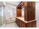 Bright bathroom with and vanity, granite countertop, dark wood cabinets, and jetted tub at 13670 N 85Th Pl, Scottsdale, AZ 85260