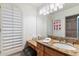 Bathroom vanity with wood cabinets, granite countertop, oversized mirror, and stylish decor at 13670 N 85Th Pl, Scottsdale, AZ 85260