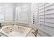 Bathroom showing white jetted tub with white shuttered windows at 13670 N 85Th Pl, Scottsdale, AZ 85260