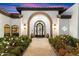 Elegant entryway featuring an arched doorway, wrought iron door, and decorative sconces, creating a grand entrance at 13670 N 85Th Pl, Scottsdale, AZ 85260