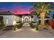 Elegant stucco home featuring a beautifully landscaped yard with a palm tree and a decorative wrought iron door at 13670 N 85Th Pl, Scottsdale, AZ 85260