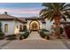 Elegant stucco home featuring a beautifully landscaped yard with a palm tree and a decorative wrought iron door at 13670 N 85Th Pl, Scottsdale, AZ 85260