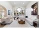 Bright living room featuring a large window, a white sofa, and a unique wooden coffee table at 13670 N 85Th Pl, Scottsdale, AZ 85260