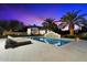 Backyard pool area features lounge chairs, palms, and a travertine tiled deck, creating a resort-like ambiance at 13670 N 85Th Pl, Scottsdale, AZ 85260