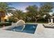 Sparkling pool with a decorative water feature, set amidst lush landscaping and travertine tile at 13670 N 85Th Pl, Scottsdale, AZ 85260