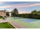 Tennis court with lush greenery and a view of the home at 13670 N 85Th Pl, Scottsdale, AZ 85260