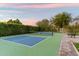 A tennis court surrounded by lush green hedges and trees, providing a private and picturesque setting at 13670 N 85Th Pl, Scottsdale, AZ 85260