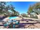 This backyard features a sparkling pool, a spacious patio, lush landscaping, and mature trees at 14460 N 100Th Way, Scottsdale, AZ 85260