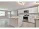 Updated kitchen featuring white cabinetry, stainless steel appliances, and island at 15032 N 24Th N Pl, Phoenix, AZ 85032