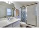 Bright bathroom features shower with glass doors, white vanity, and well-lit mirror at 17200 W Bell Rd # 357, Surprise, AZ 85374