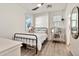 Well-lit bedroom with a black metal bed frame, ceiling fan, and vanity area at 1724 E Bridgeport Pkwy, Gilbert, AZ 85295