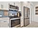 Modern kitchen with stainless steel appliances, white cabinetry, and a stylish blue tile backsplash, well-lit and functional at 1724 E Bridgeport Pkwy, Gilbert, AZ 85295