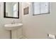 Bright powder room with a pedestal sink, large mirror, and a decorative sign at 1724 E Bridgeport Pkwy, Gilbert, AZ 85295